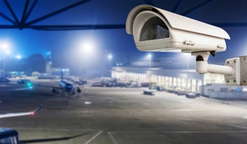 A close-up view of a security perimeter at a German airport with police vehicles nearby.