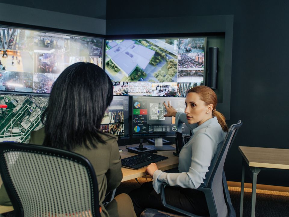 Operators Security operators discussing a university floor plan on a computer monitor