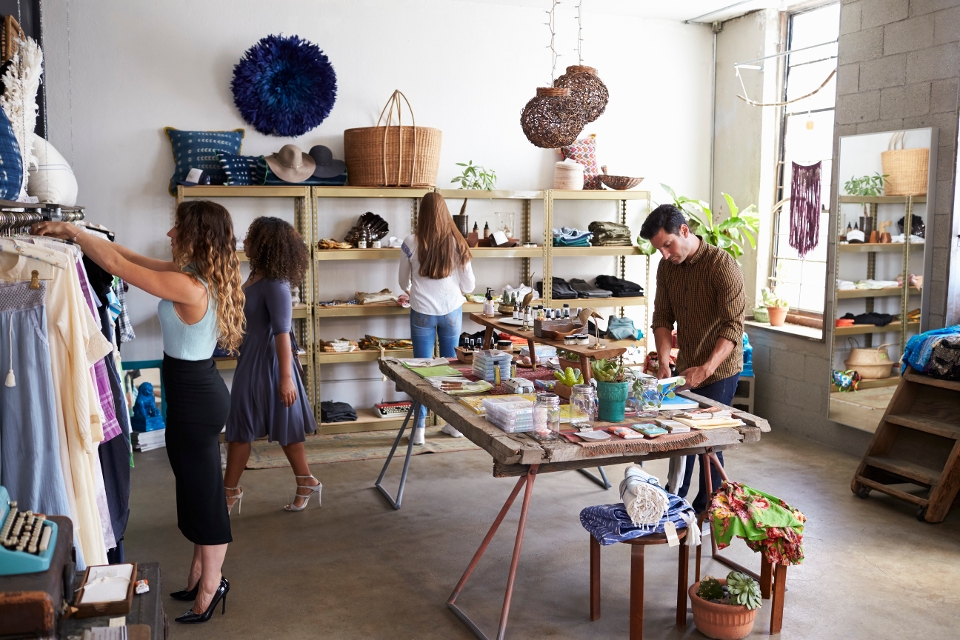 A retail business owner arranges products on a display table