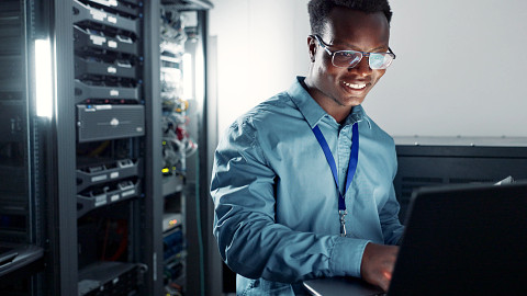 IT specialist monitors system status. He is confident in his system's ability to deliver best-in -class reliability, with failover architecture and redundancy options.