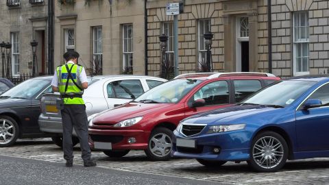Agente policial emitiendo una multa por una infracción de estacionamiento