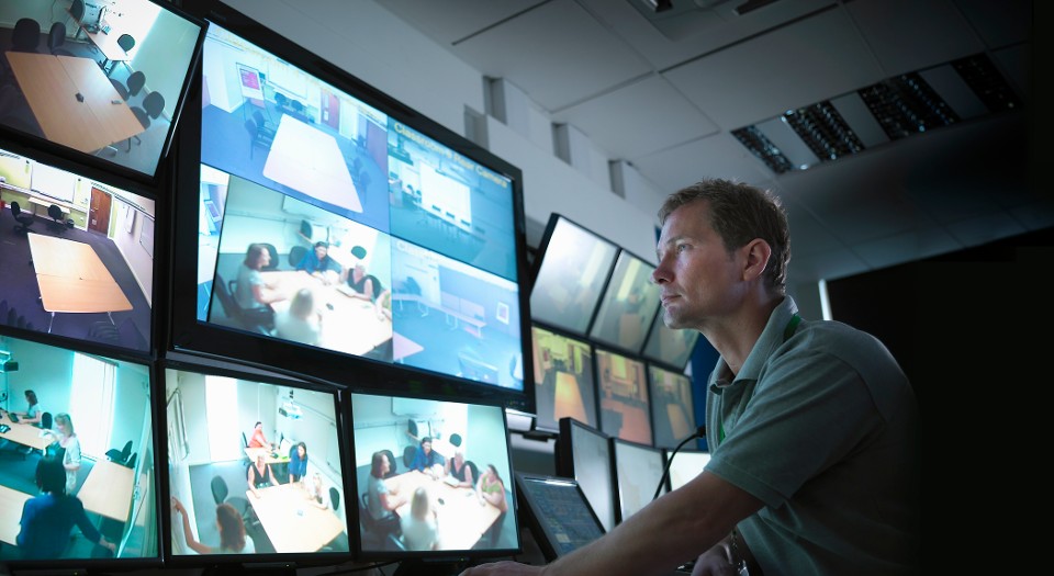 A security operator watching multiple security camera screens
