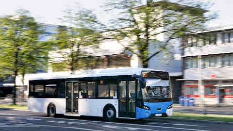 A city bus in motion equipped with integrated transit security solutions.