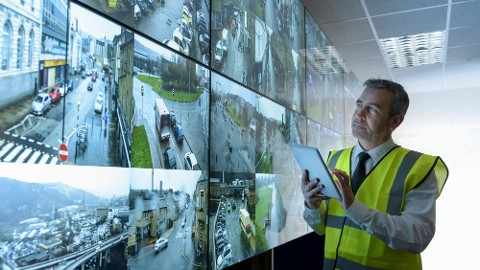 Police officers using security solutions on bikes patrolling by a park and a canal.