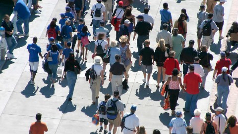 Menigte studenten die over een slimme campus loopt, waarbij het campusbeveiligingssysteem de veiligheid van studenten en crowdmanagement ondersteunt tijdens evenementen met een hoge bezettingsgraad. 
